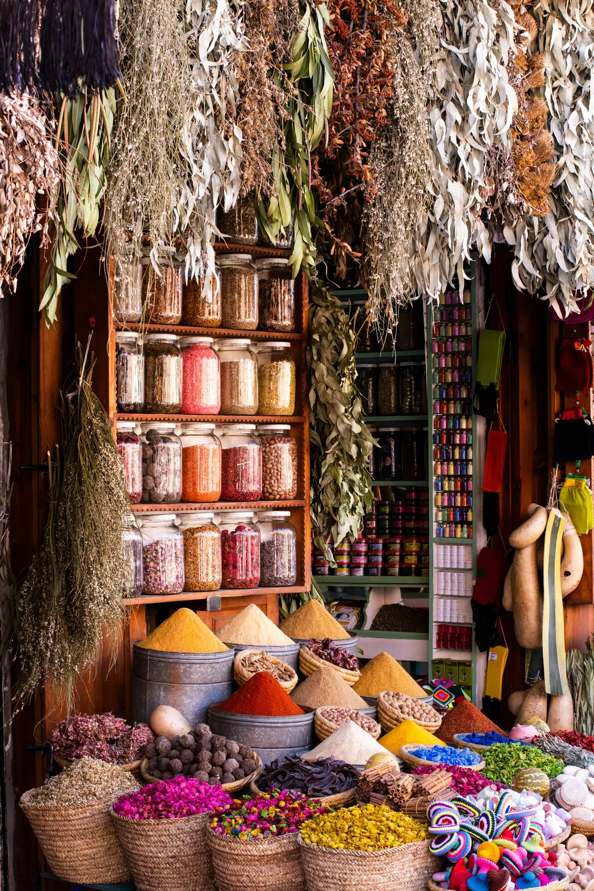 Moroccan spice and herb stall filled with jars, baskets, and dried botanicals
