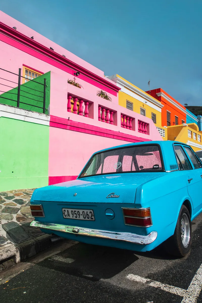 Colorful coastal street with a vintage blue car