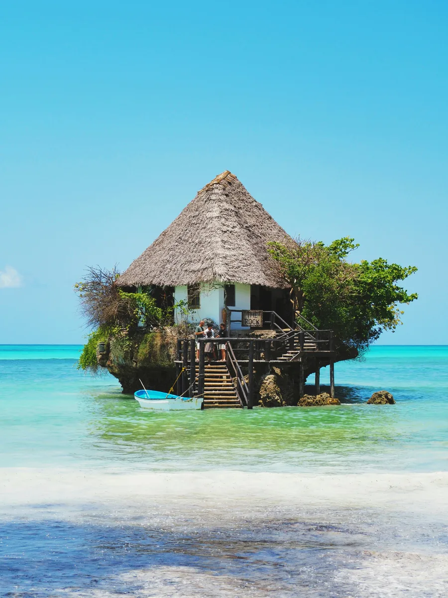 A small restaurant set on a rock in turquoise water