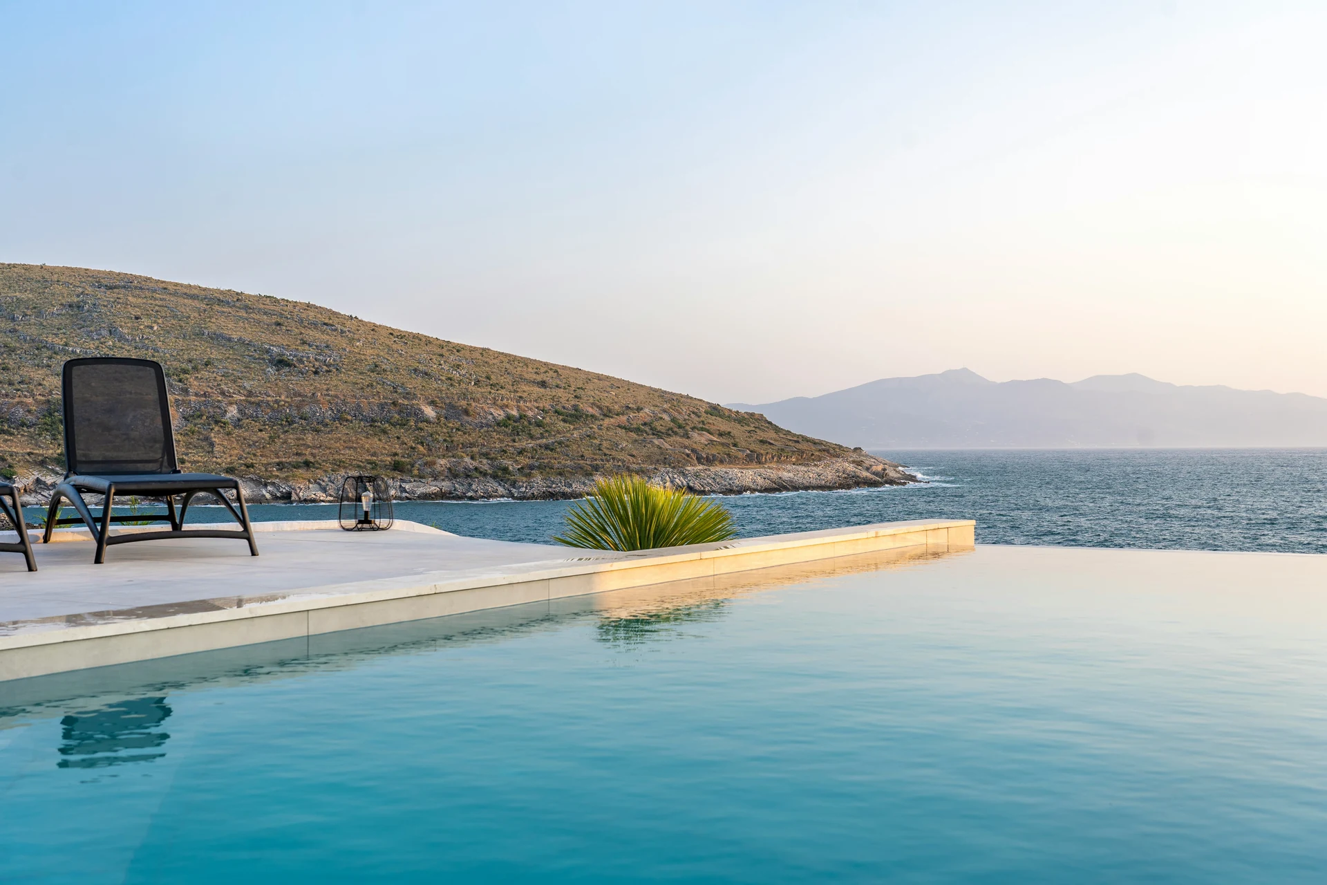 Infinity pool overlooking the sea and distant mountains