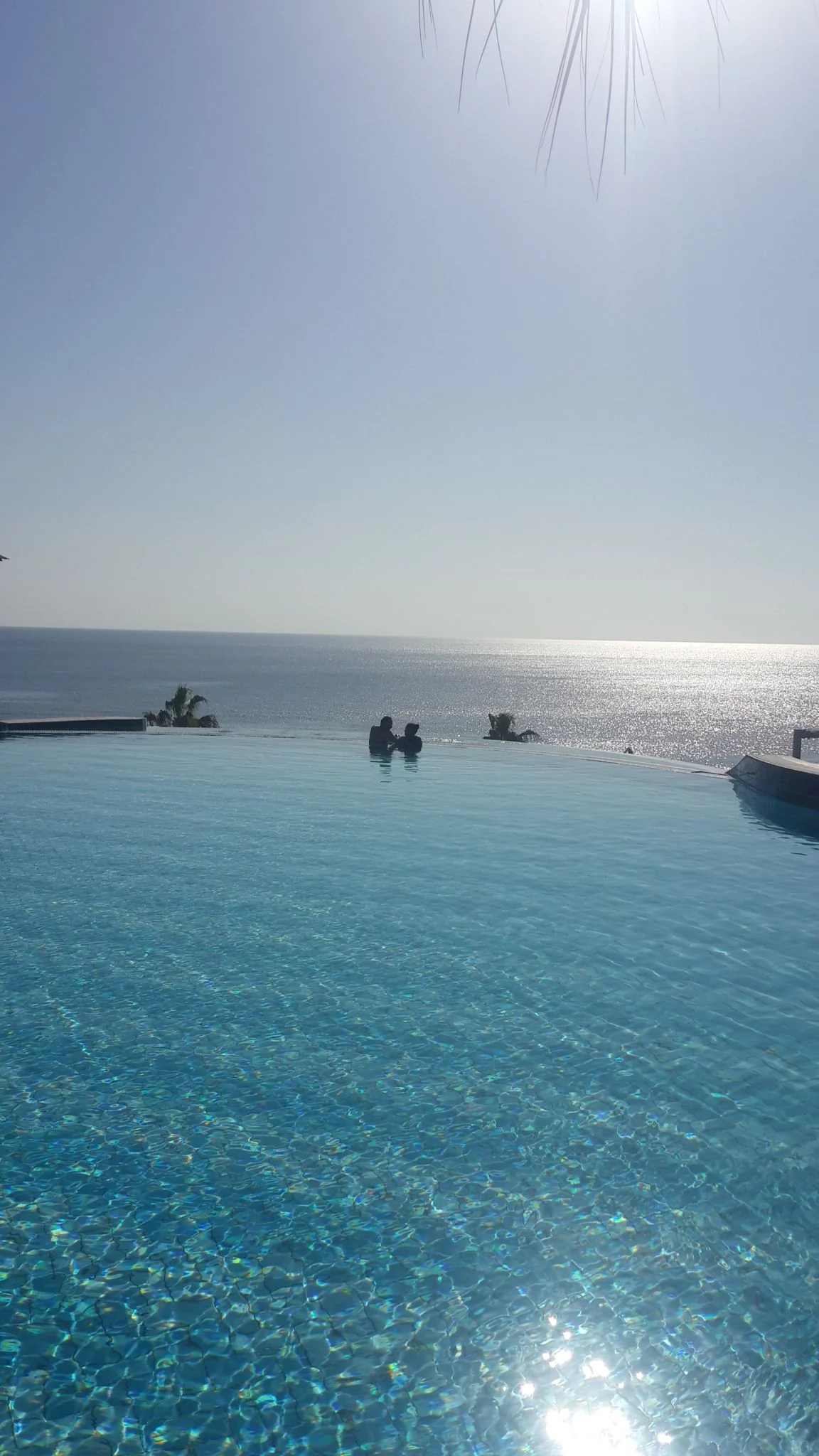 Infinity pool overlooking a bright sea horizon