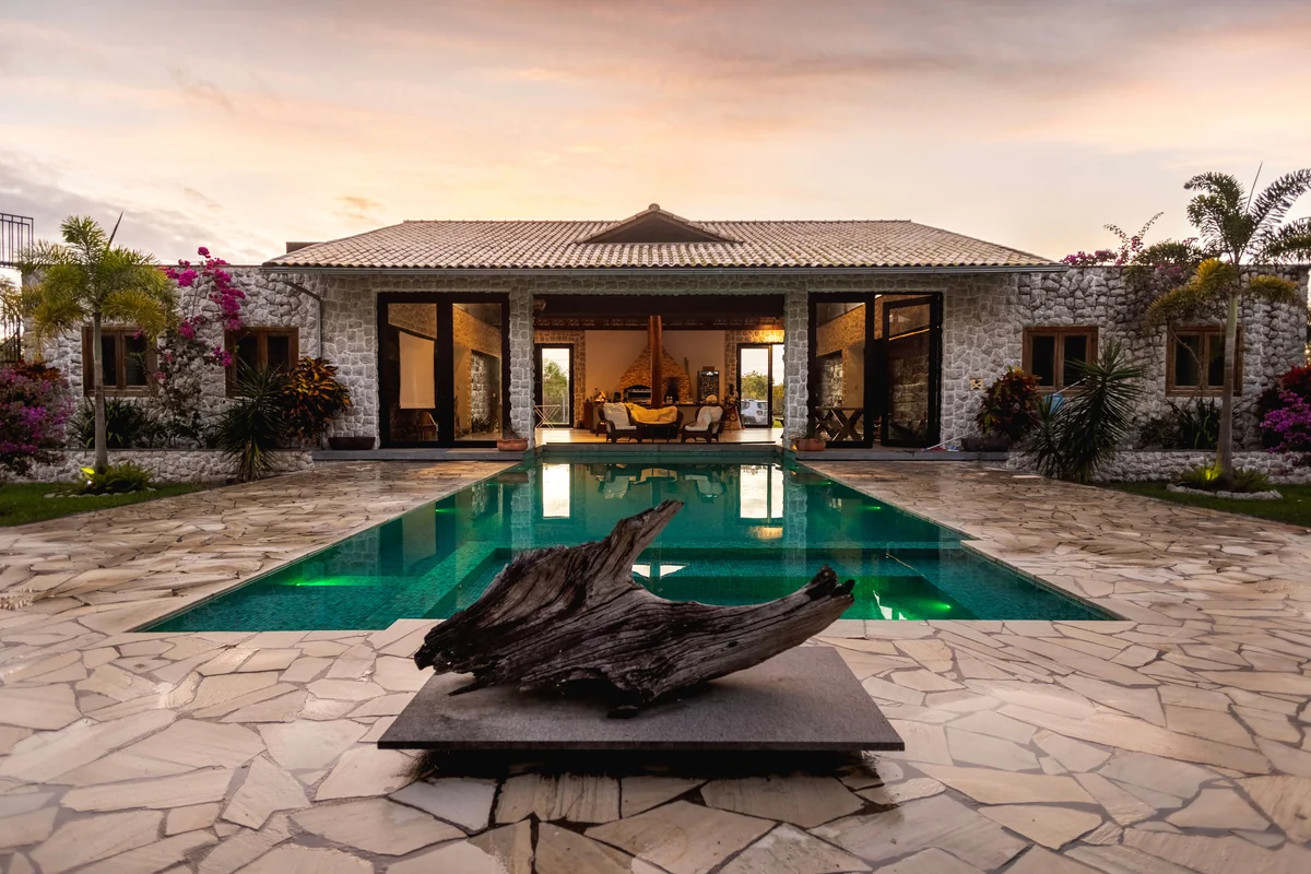 Stone villa and swimming pool at sunset