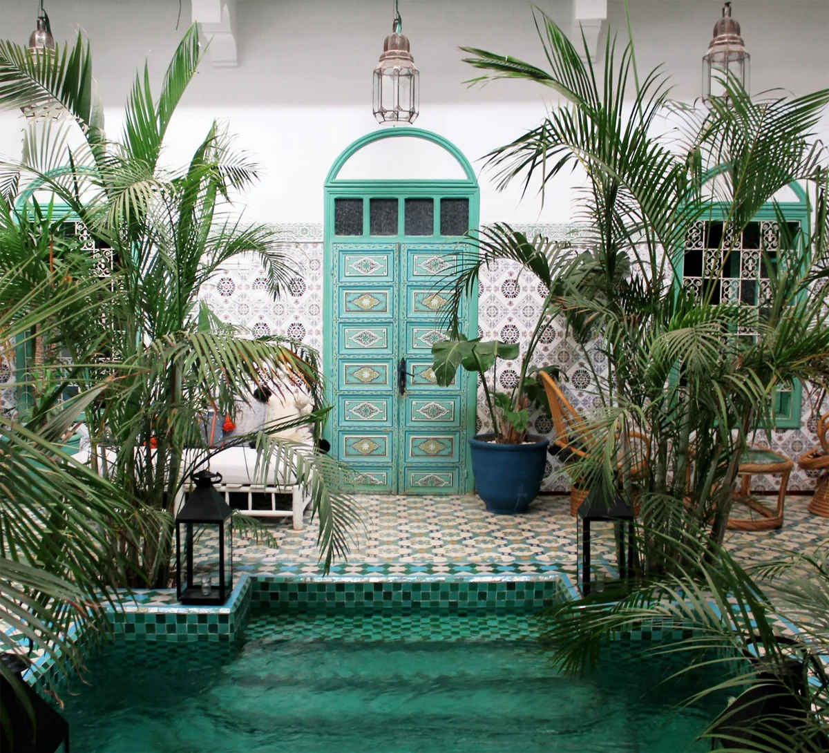 Refined Moroccan riad pool with palms and handcrafted tiles