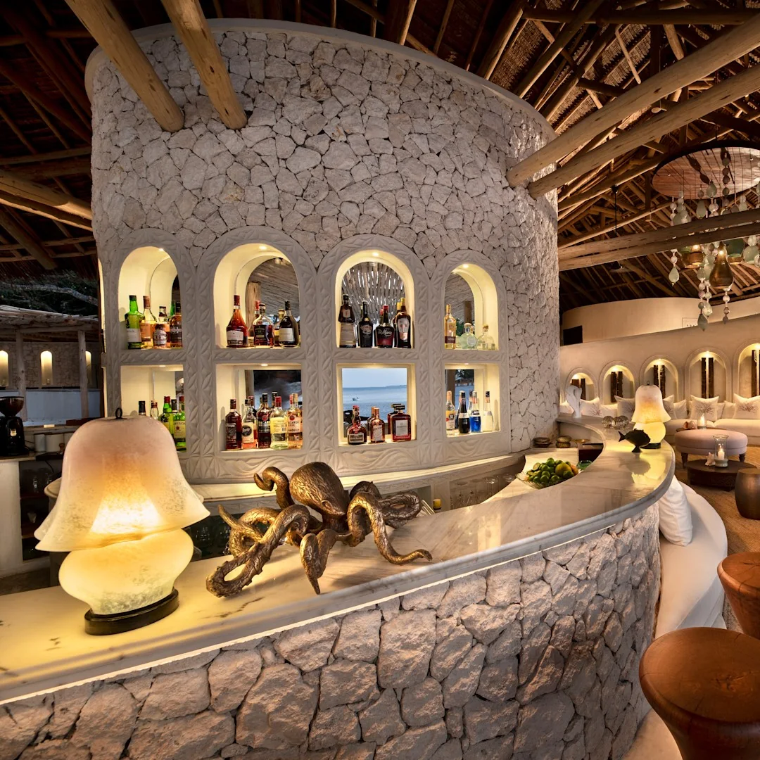 Island guest area bar with carved stone arches and warm lighting